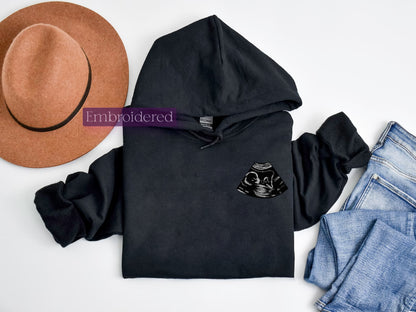 a black hoodie, hat, jeans and a pair of shoes