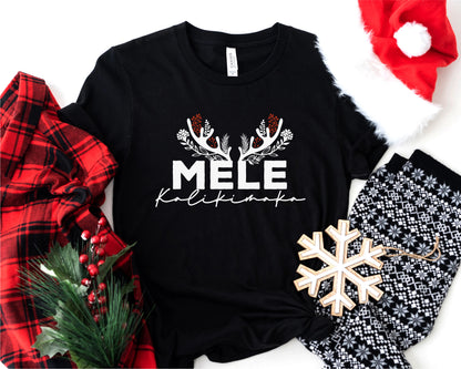 A black t-shirt with the text "MELE Kalikimaka" printed on it, along with a red and black plaid shirt, a Santa hat, a snowflake ornament, and a pair of pajama pants.