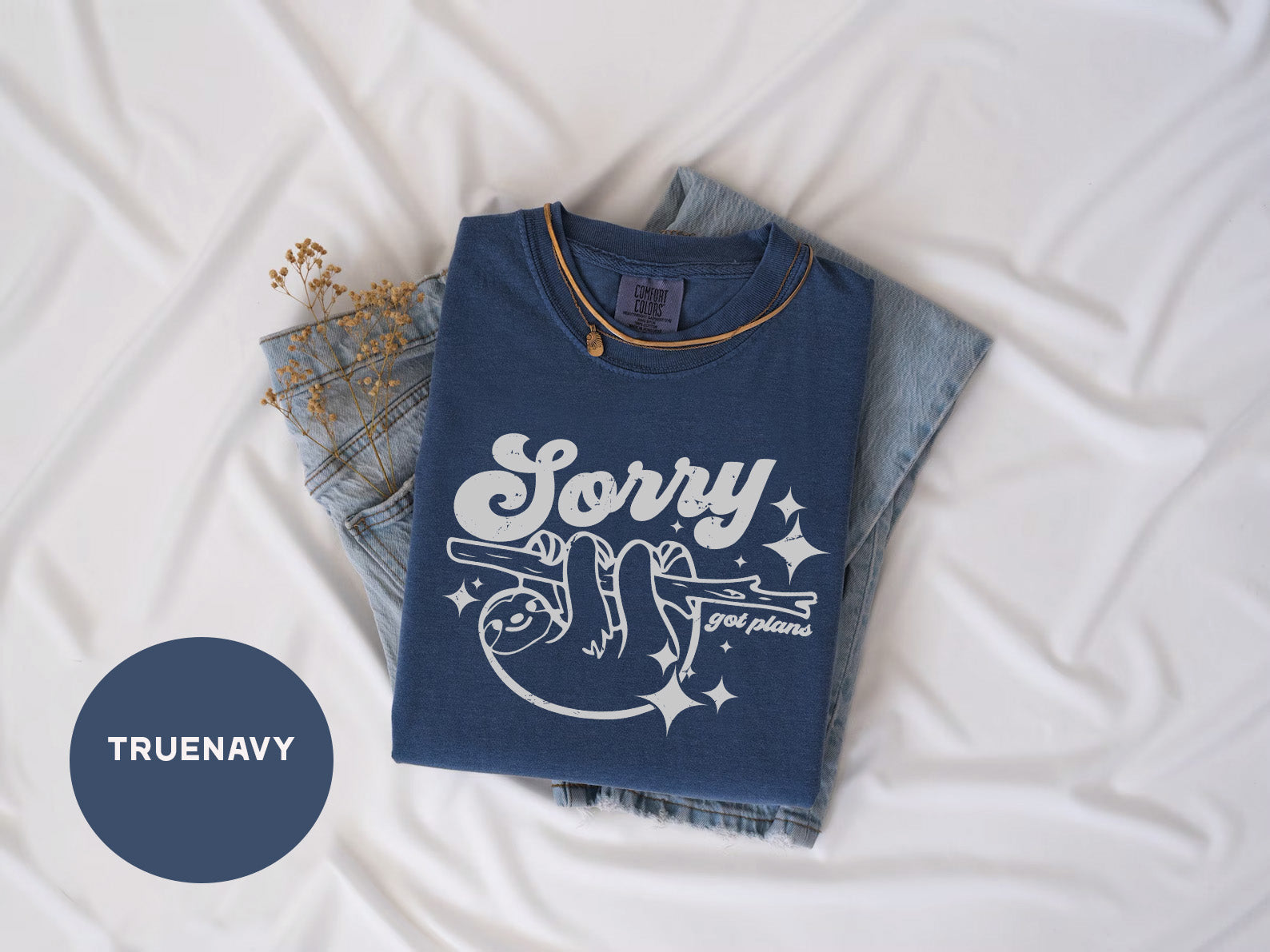 a t - shirt that says sorry on it next to a pair of jeans