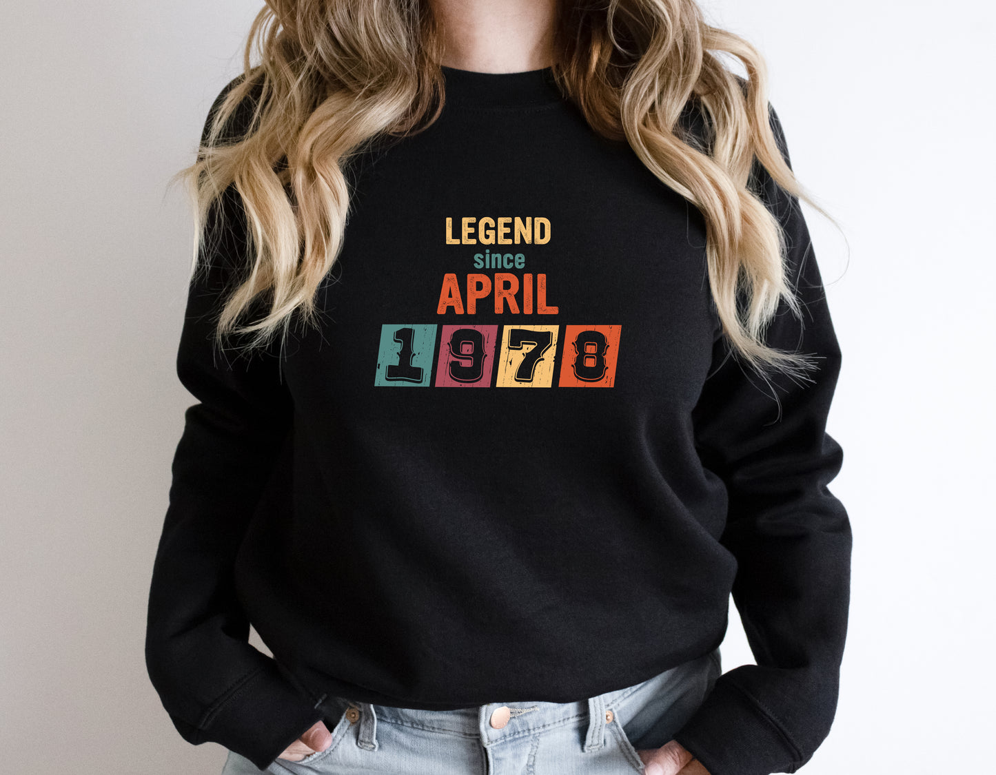 A person wearing a black sweatshirt with the text "LEGEND SINCE APRIL 1978" printed on it.