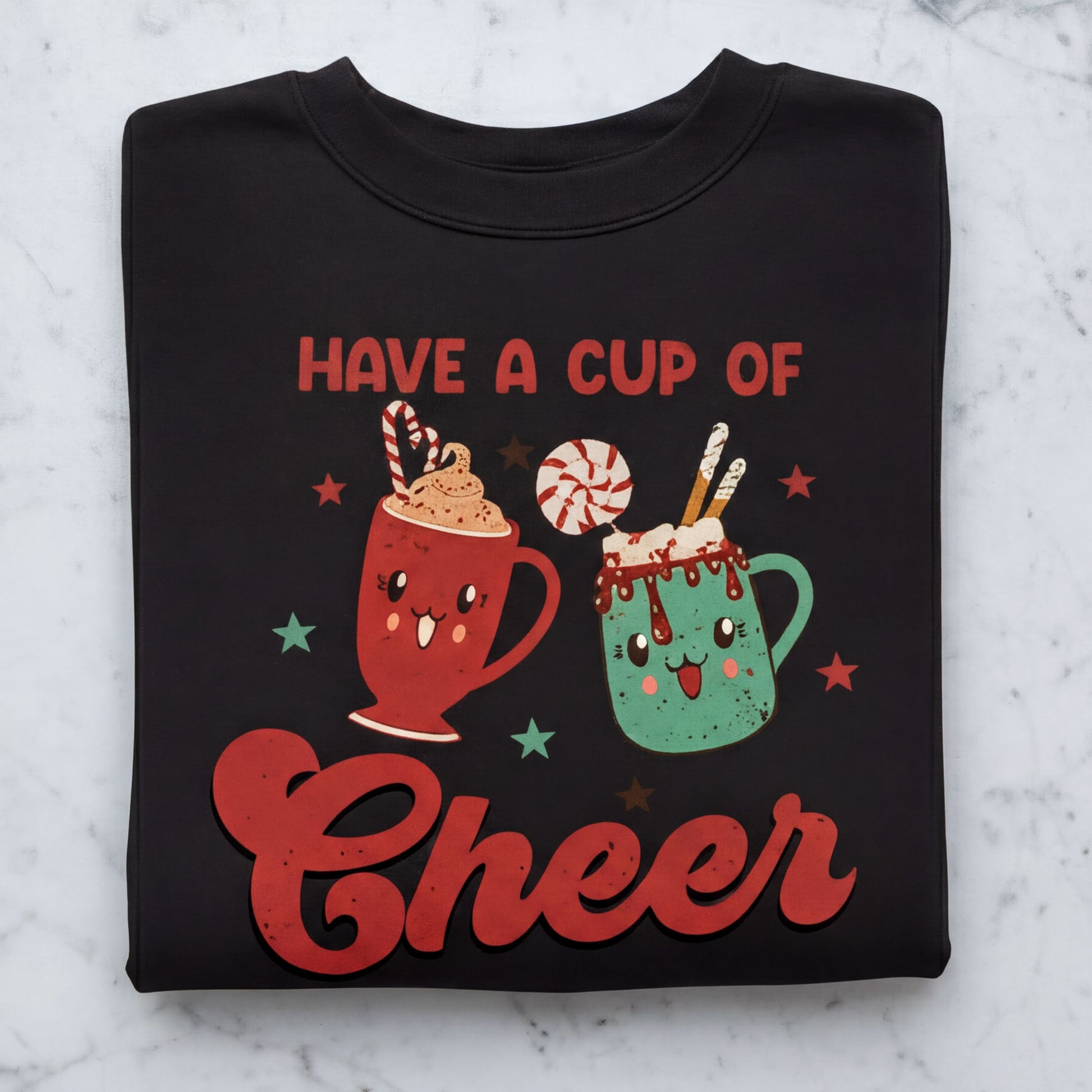 A black sweatshirt with a graphic design featuring two cheerful, cartoon-like mugs with whipped cream and candy decorations, along with the text "Have a cup of cheer".