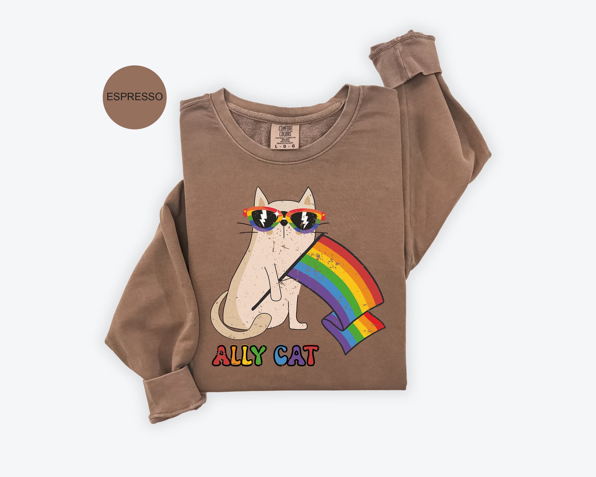 a brown shirt with a cat wearing sunglasses and a rainbow