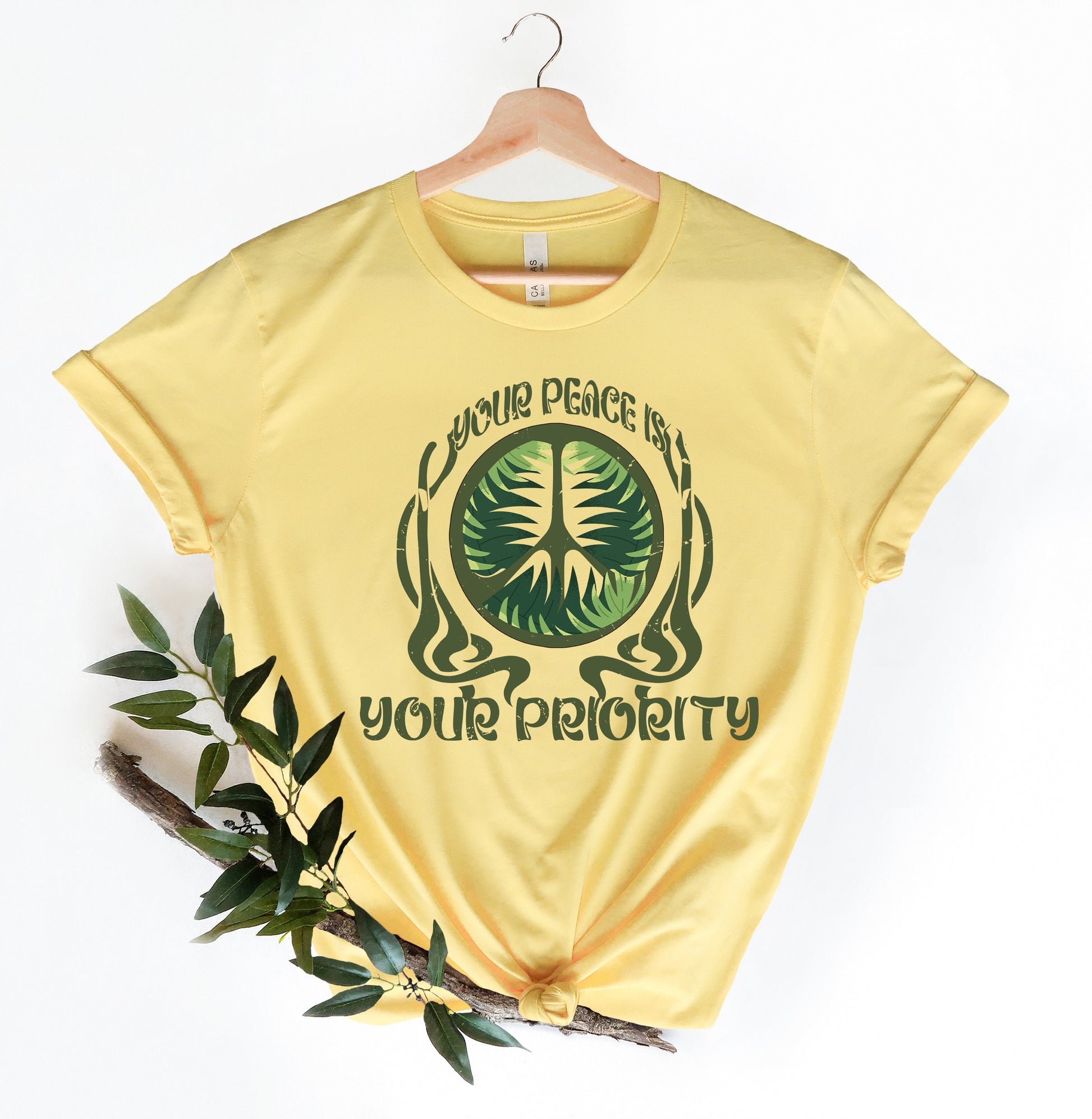 a yellow t - shirt with a green tree on it