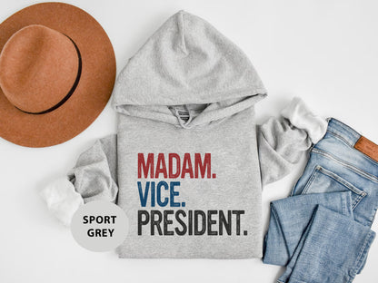 a hat, sweatshirt, jeans, and a pair of shoes on a white surface