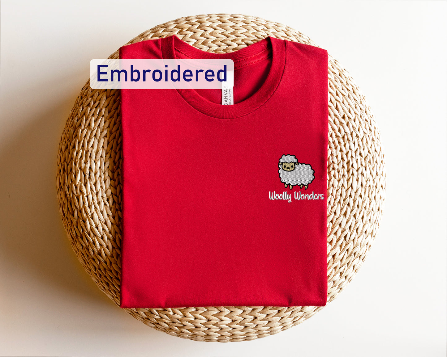 a red shirt with a sheep embroidered on it