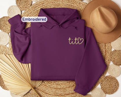 a purple hoodie with embroidered tico on it