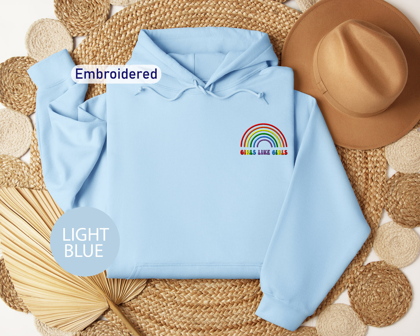 a light blue hoodie with a rainbow embroidered on it