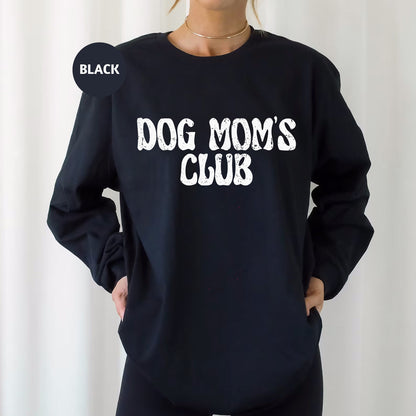 a woman wearing a black dog mom's club sweatshirt