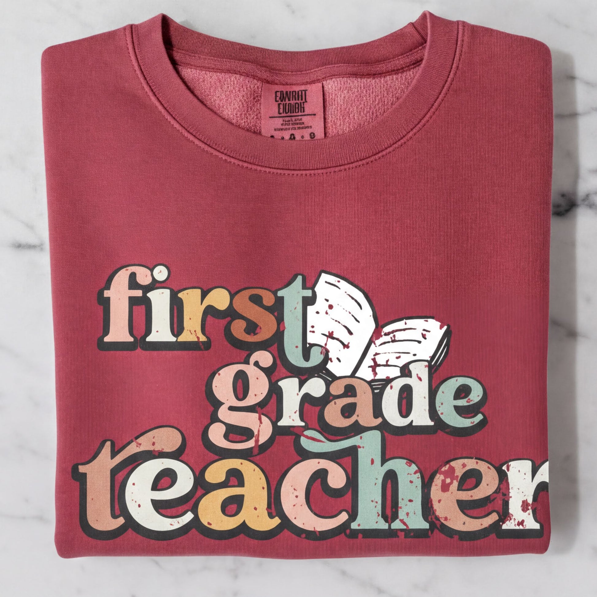 A red sweatshirt with the text "first grade teacher" printed on it.