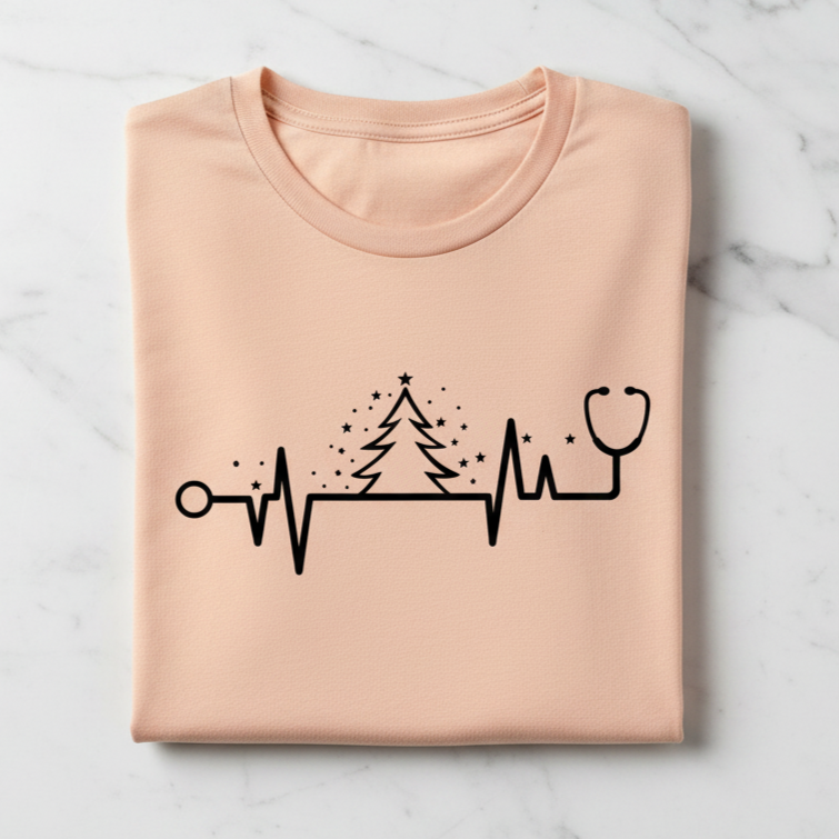 A pink t-shirt with a graphic design depicting a stethoscope and a Christmas tree with stars.