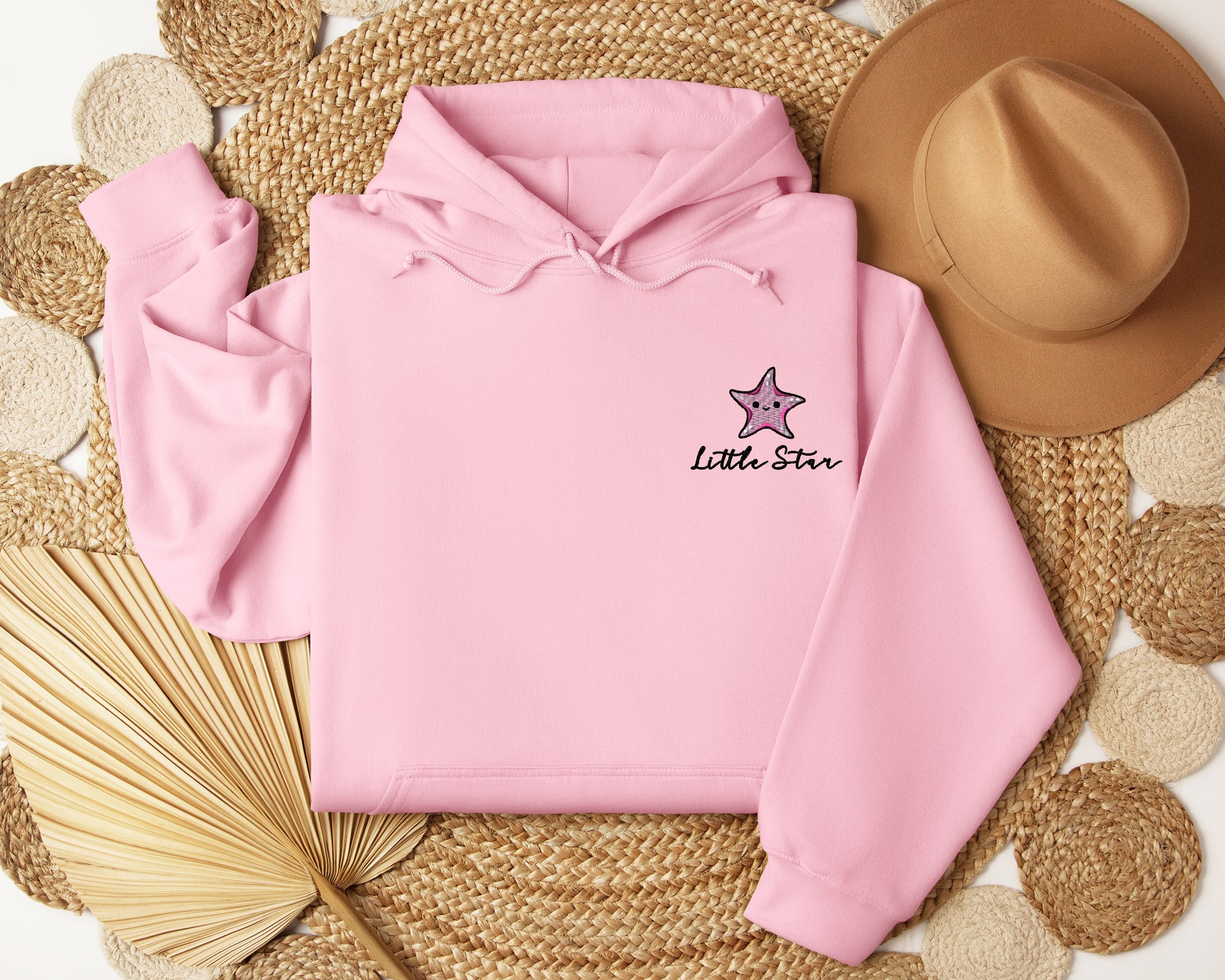 a pink hoodie with a star embroidered on it