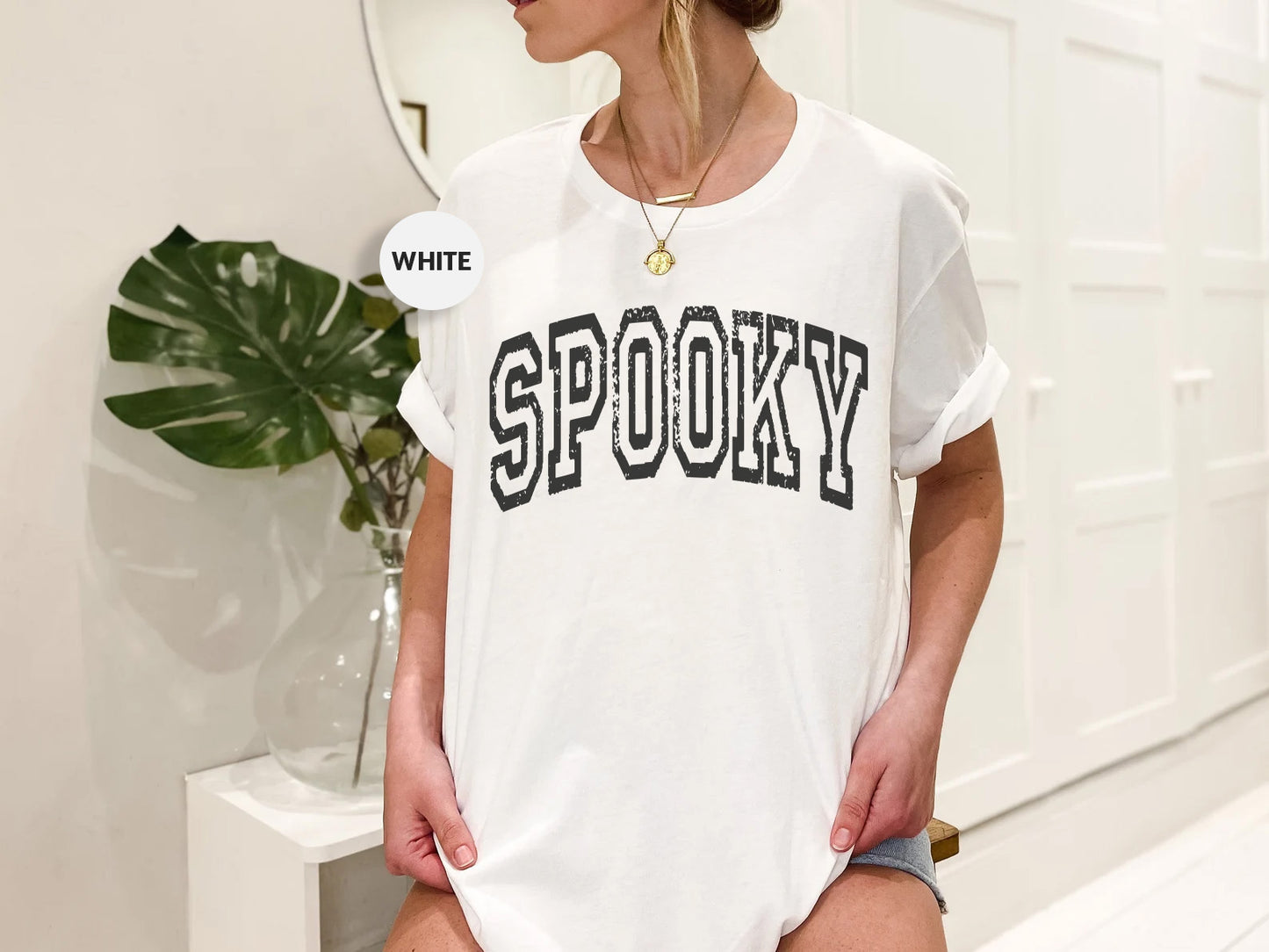 a woman wearing a white shirt with the word spooky on it