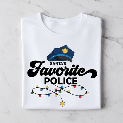 A white t-shirt with a graphic design featuring a police officer's hat and the text "Santa's Favorite Police" along with colorful lights.