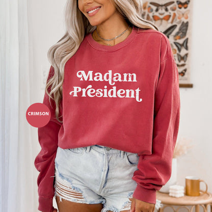 a woman wearing a red sweatshirt that says madam president