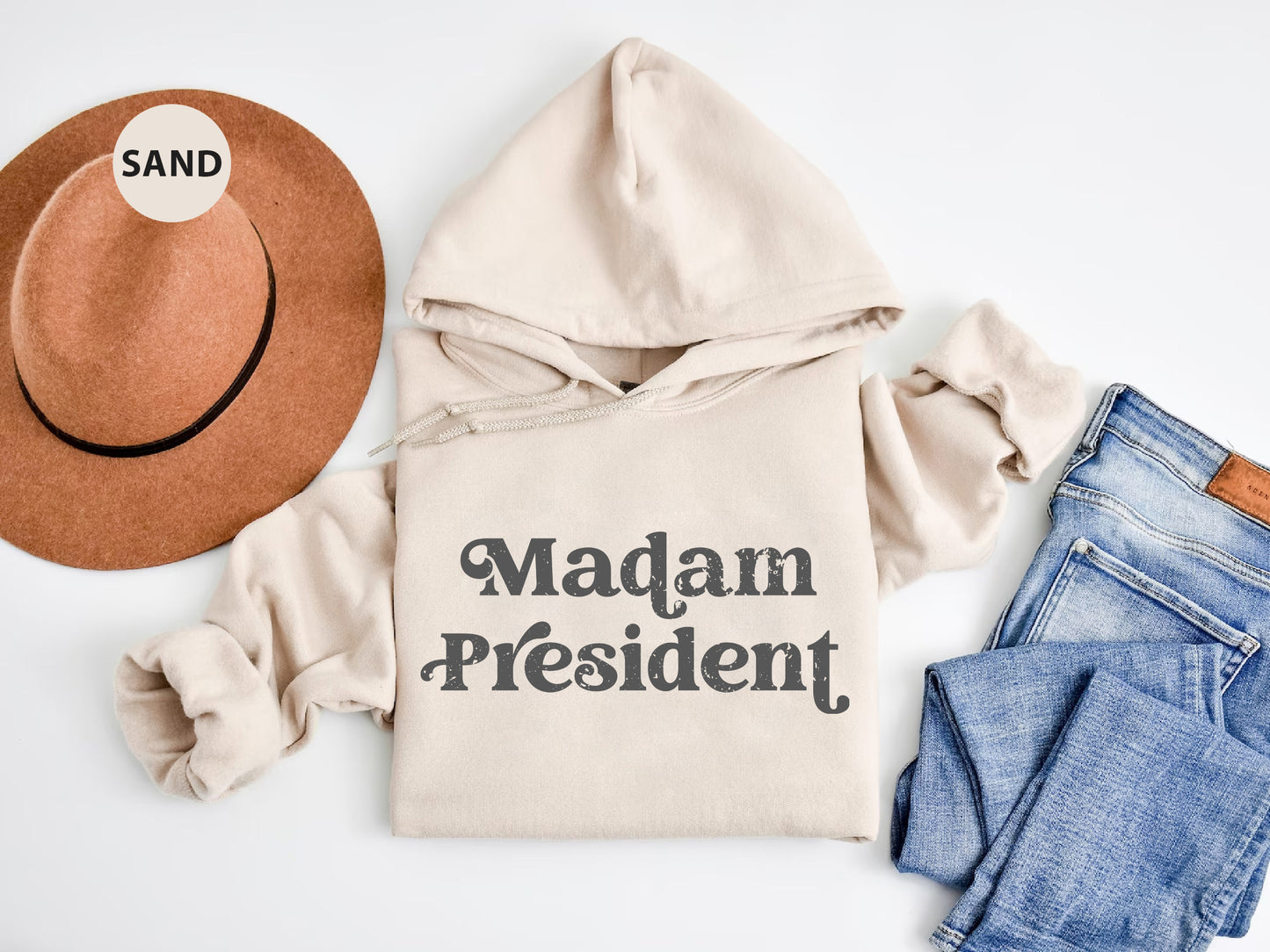 a white sweatshirt with the words madam president on it next to a pair of jeans