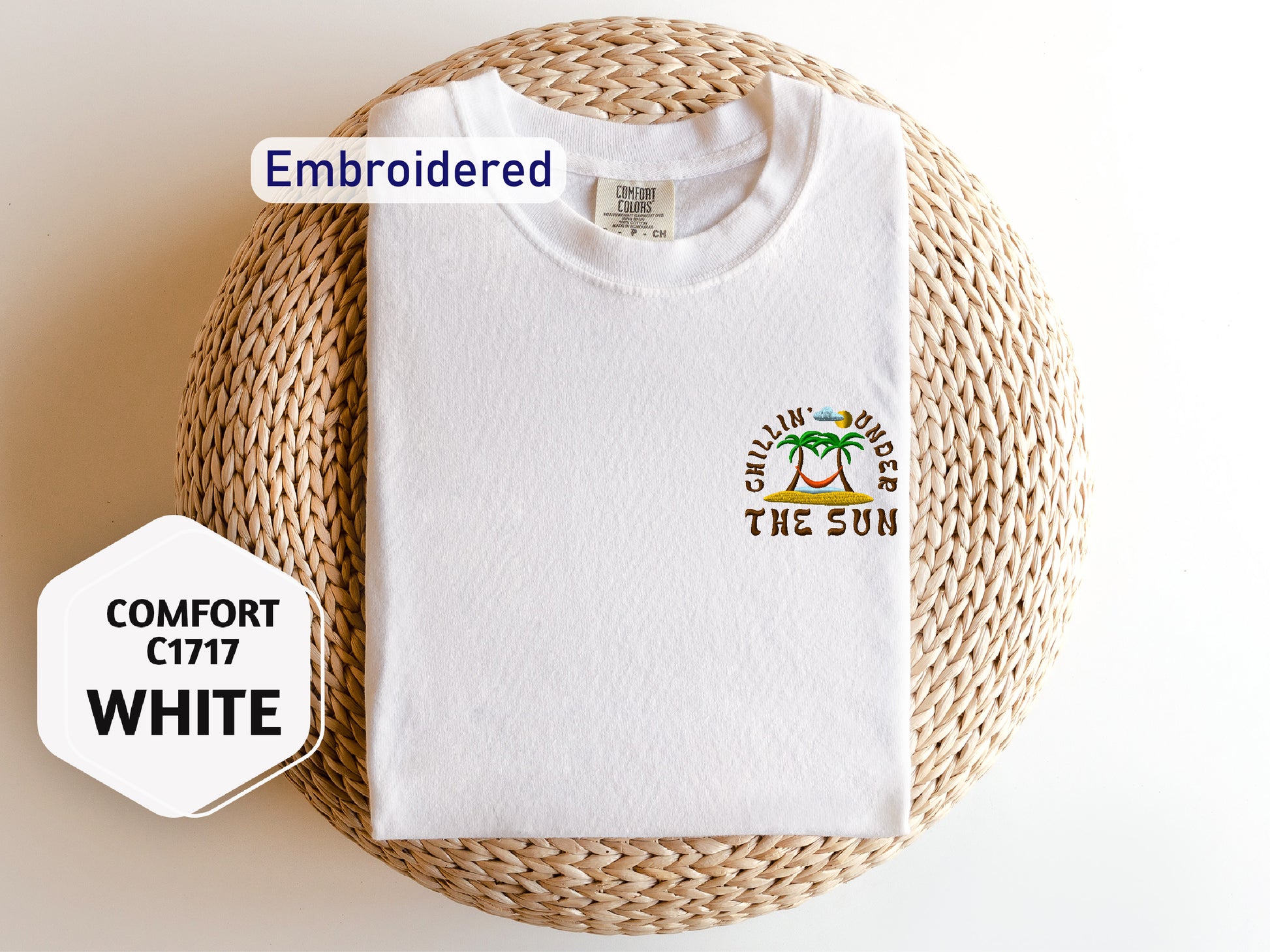 a white t-shirt with a tropical design, laid out on a woven basket.