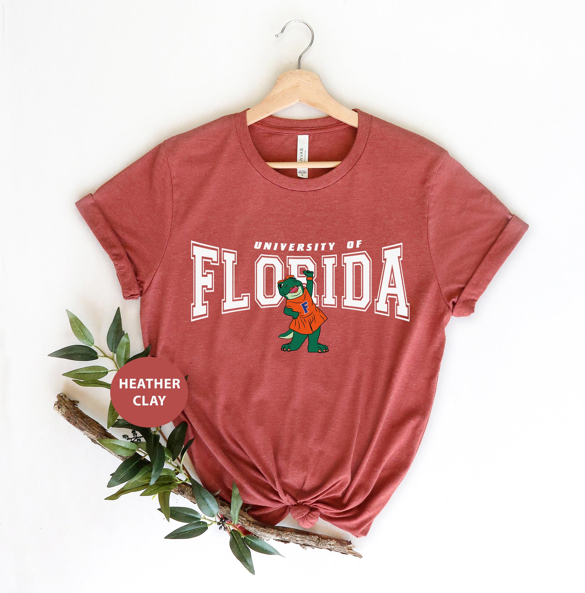 a red florida t - shirt sitting on top of a wooden hanger