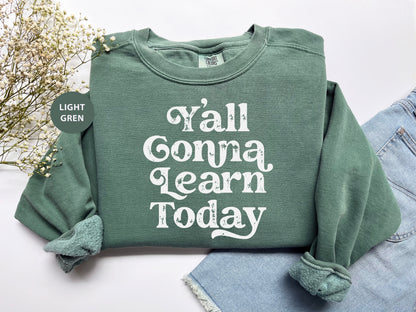 a green sweatshirt with the words y'all conna learn today printed on it