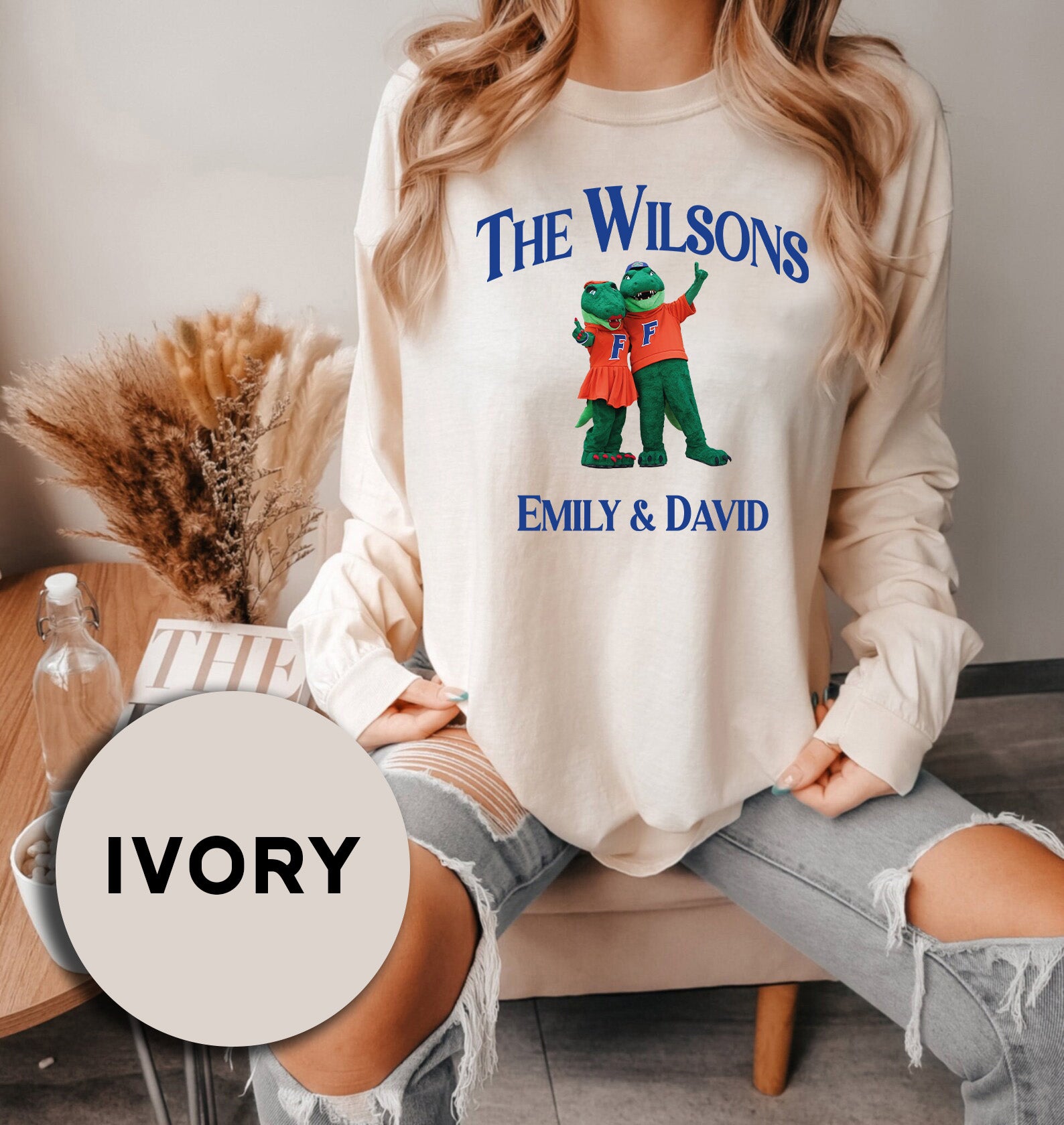 a woman sitting on a couch wearing a sweatshirt with the words, the wilsons