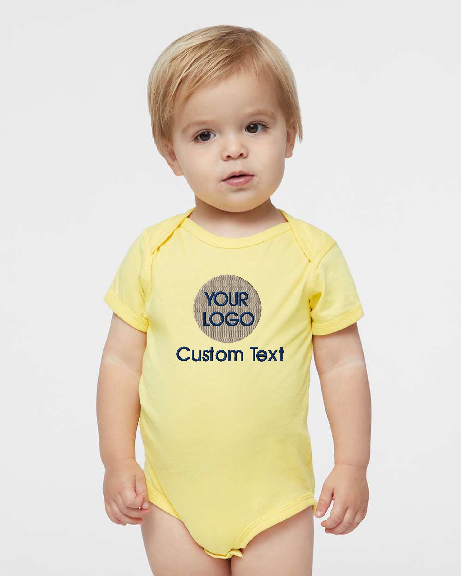 a toddler wearing a yellow bodysuit with a logo on it