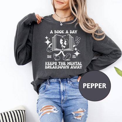 a woman wearing a book a day keeps the mental breakdown away sweatshirt