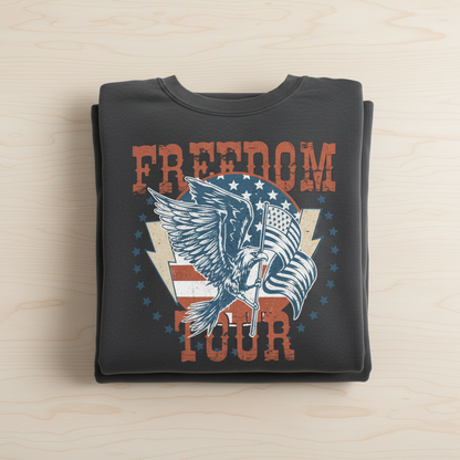 A black t-shirt with a graphic design featuring a large eagle holding a flag and the text "FREEDOM TOUR" printed on it.