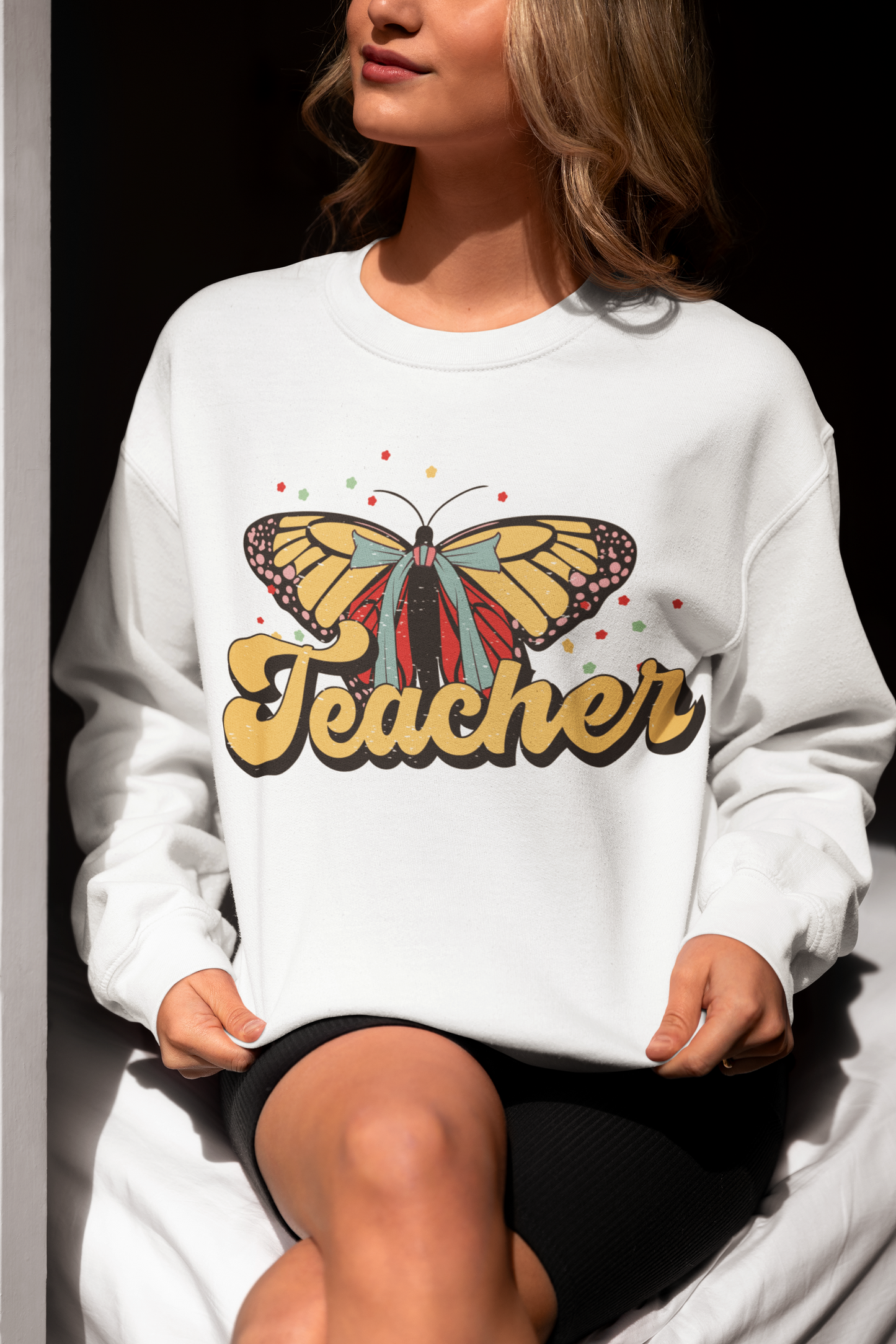 a woman wearing a white sweatshirt with a butterfly on it