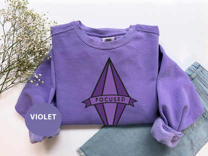 a purple sweatshirt with the word focused on it