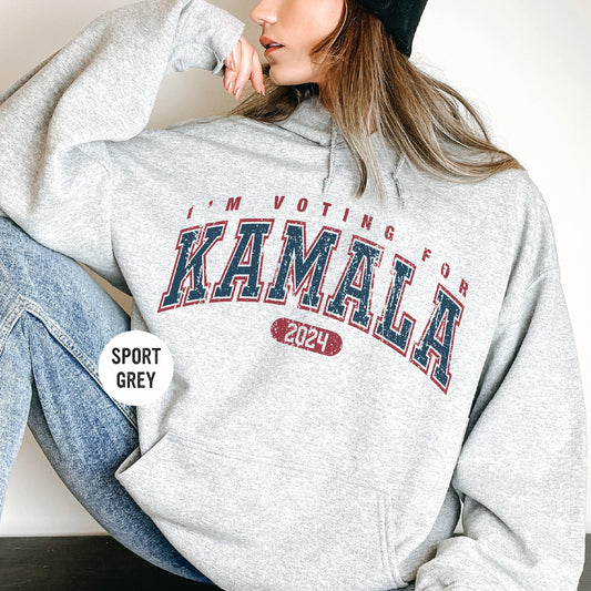 a woman sitting on the floor wearing a gray sweatshirt