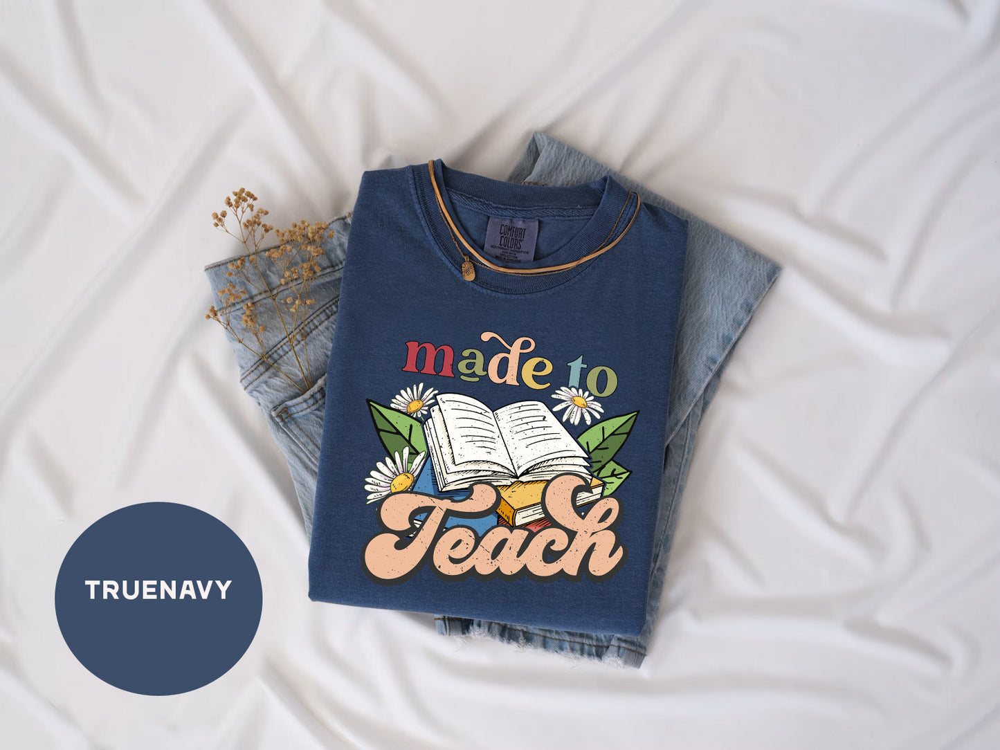 a t - shirt that says made to teach on it next to a pair of