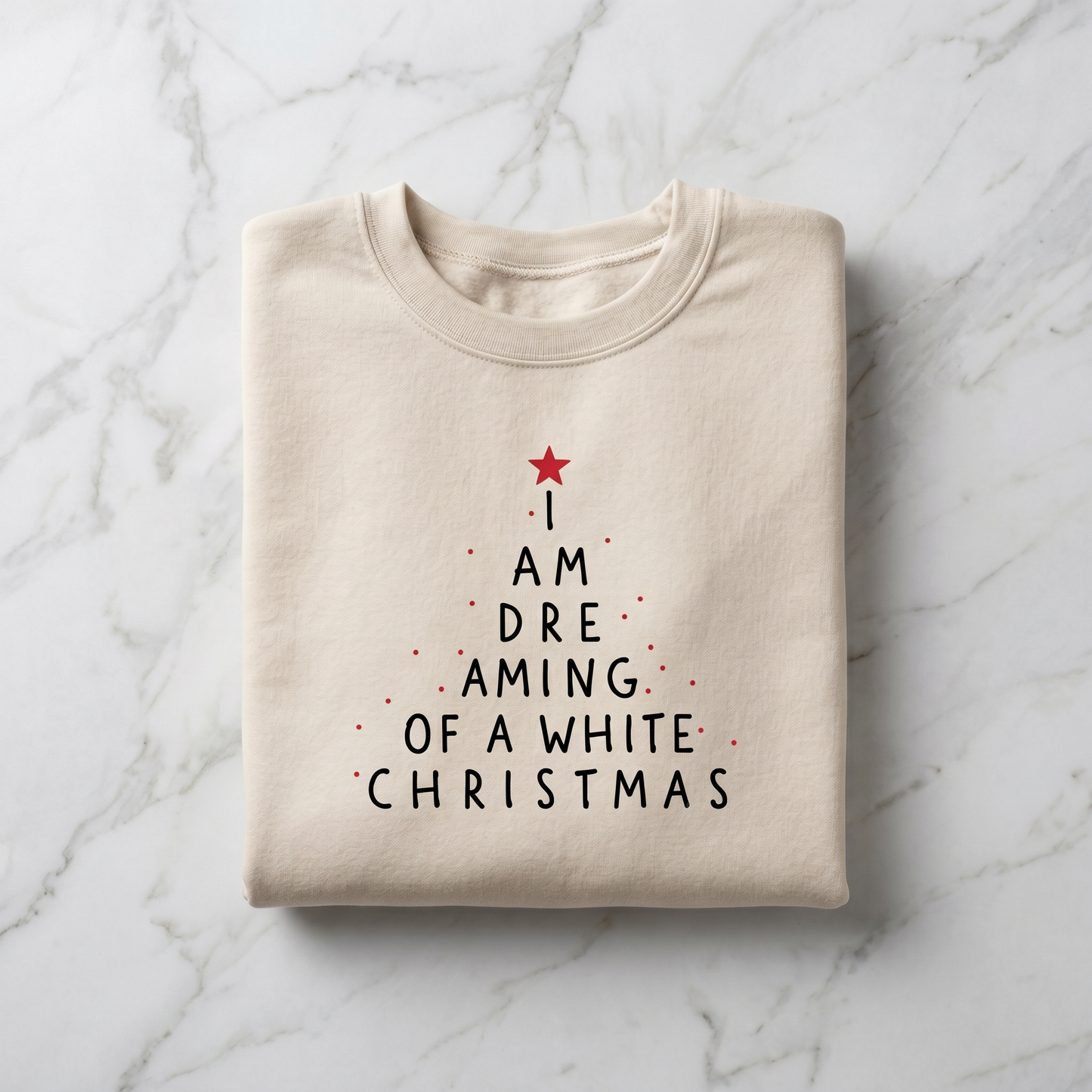 A beige t-shirt with a Christmas-themed design printed on it, featuring a tree-like shape with a red star and the text "I AM DREAMING OF A WHITE CHRISTMAS" printed on it.