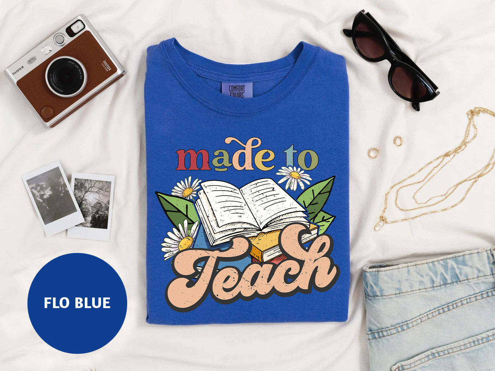 a t - shirt with a book and sunglasses on top of it