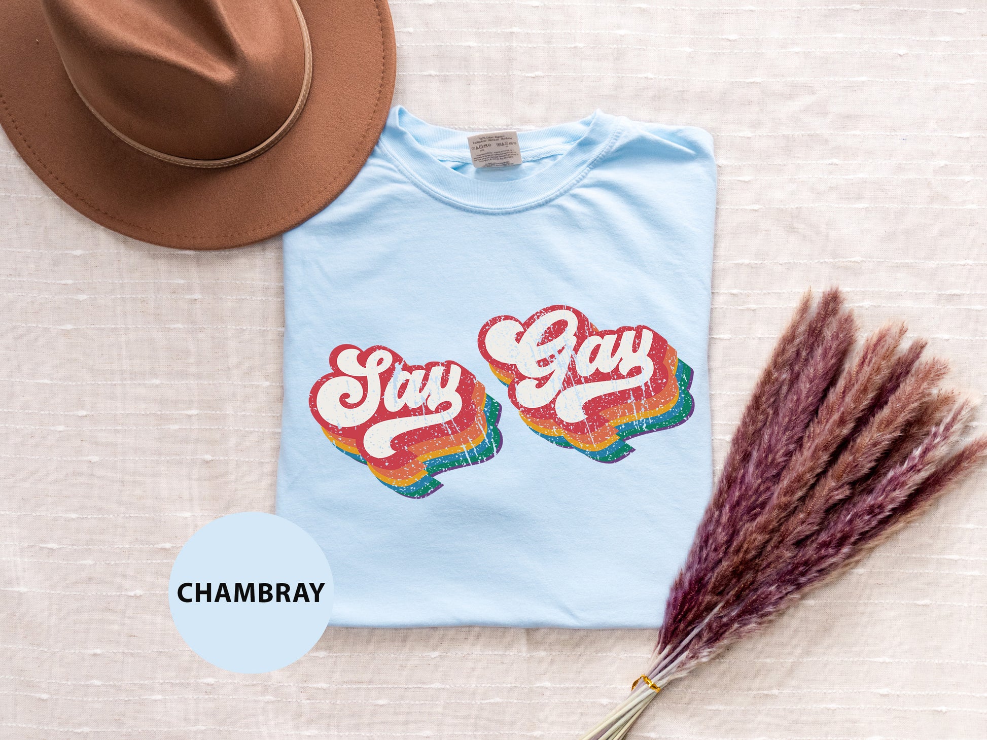 a t - shirt that says stay gay on it next to a hat