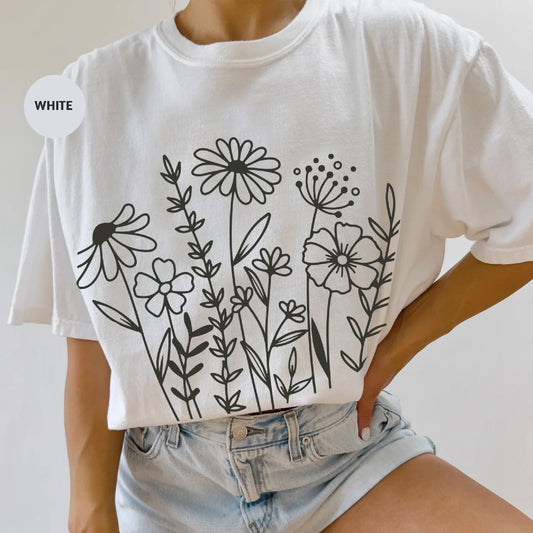a woman wearing a white t - shirt with flowers on it