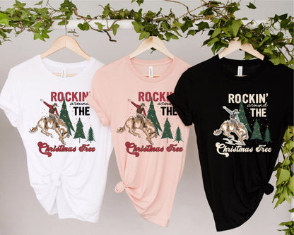 Three t-shirts hanging on a rack, each with a different design and color.