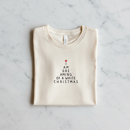 A white t-shirt with a Christmas-themed design printed on it, laid out on a marble surface.