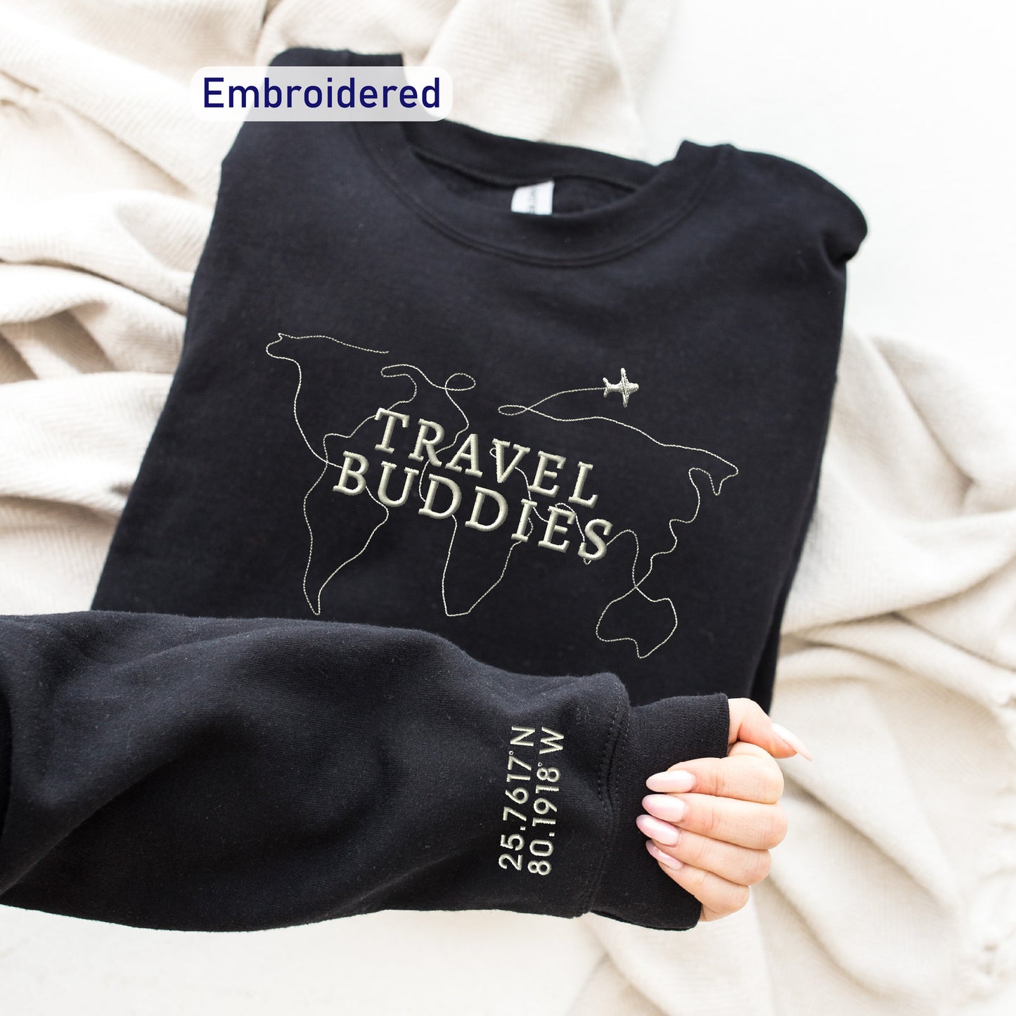 a person holding onto a black shirt with the words travel buddies on it