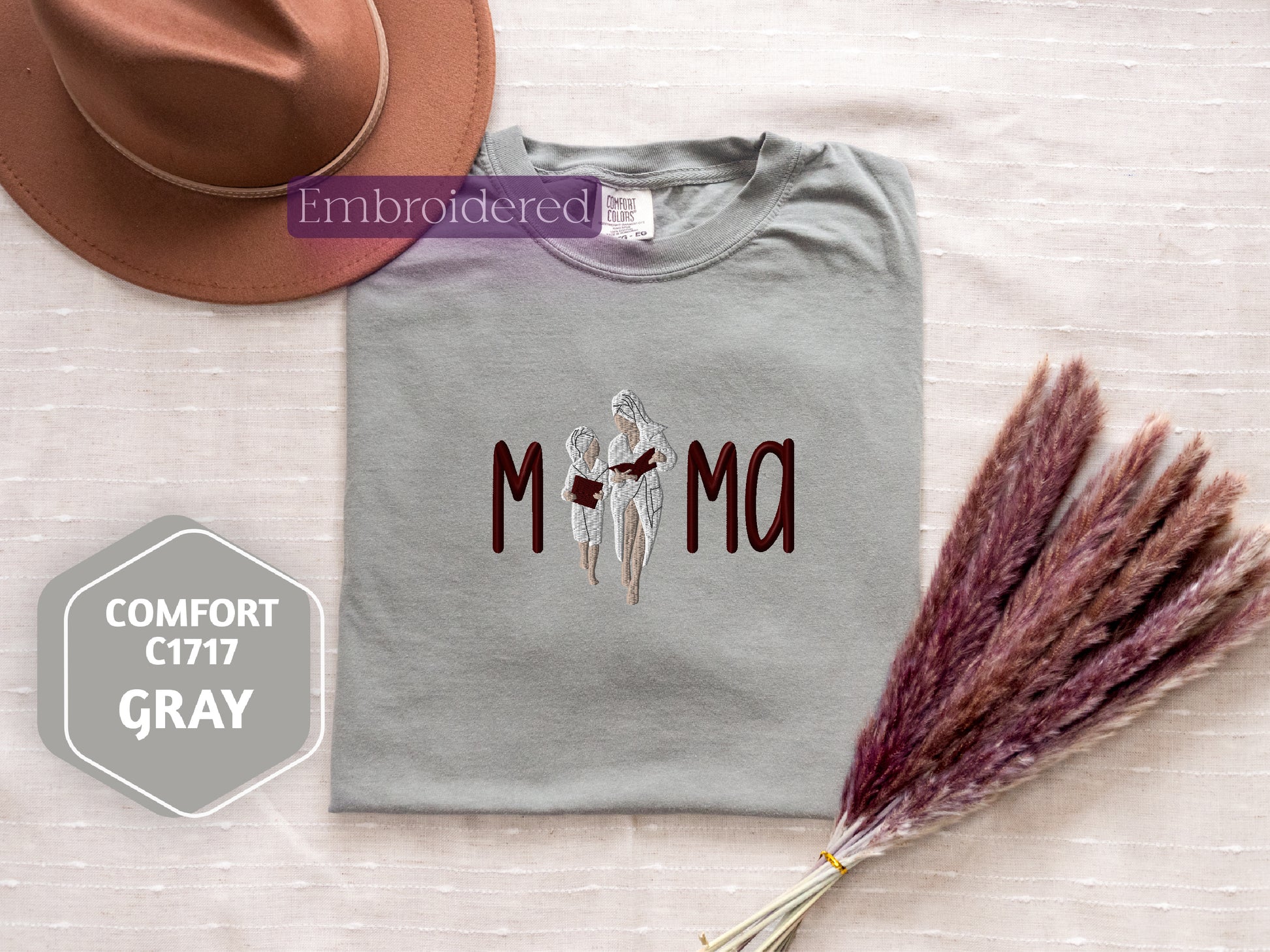 a t - shirt with the word mom on it and a hat next to it