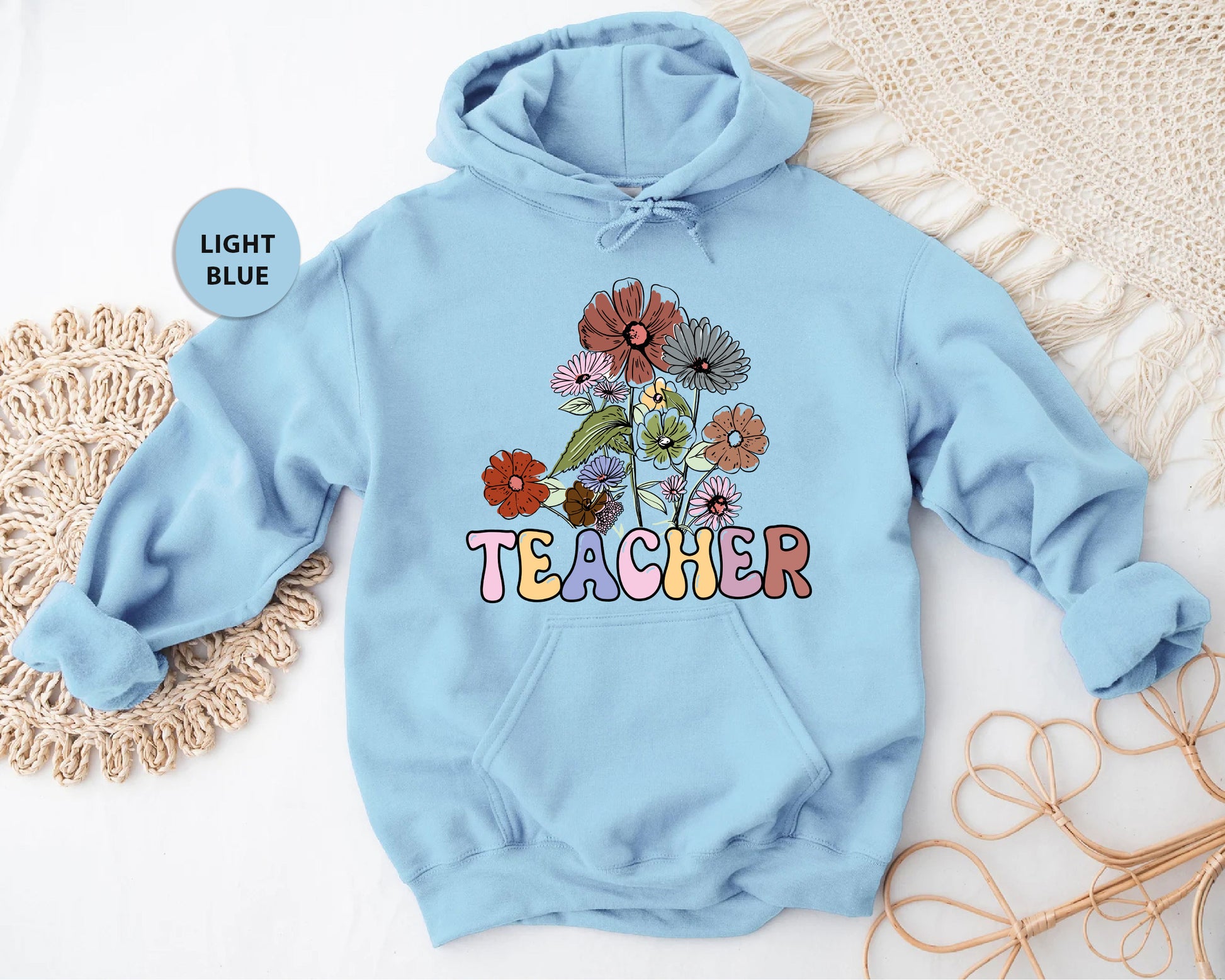 a light blue hoodie with the words teacher printed on it