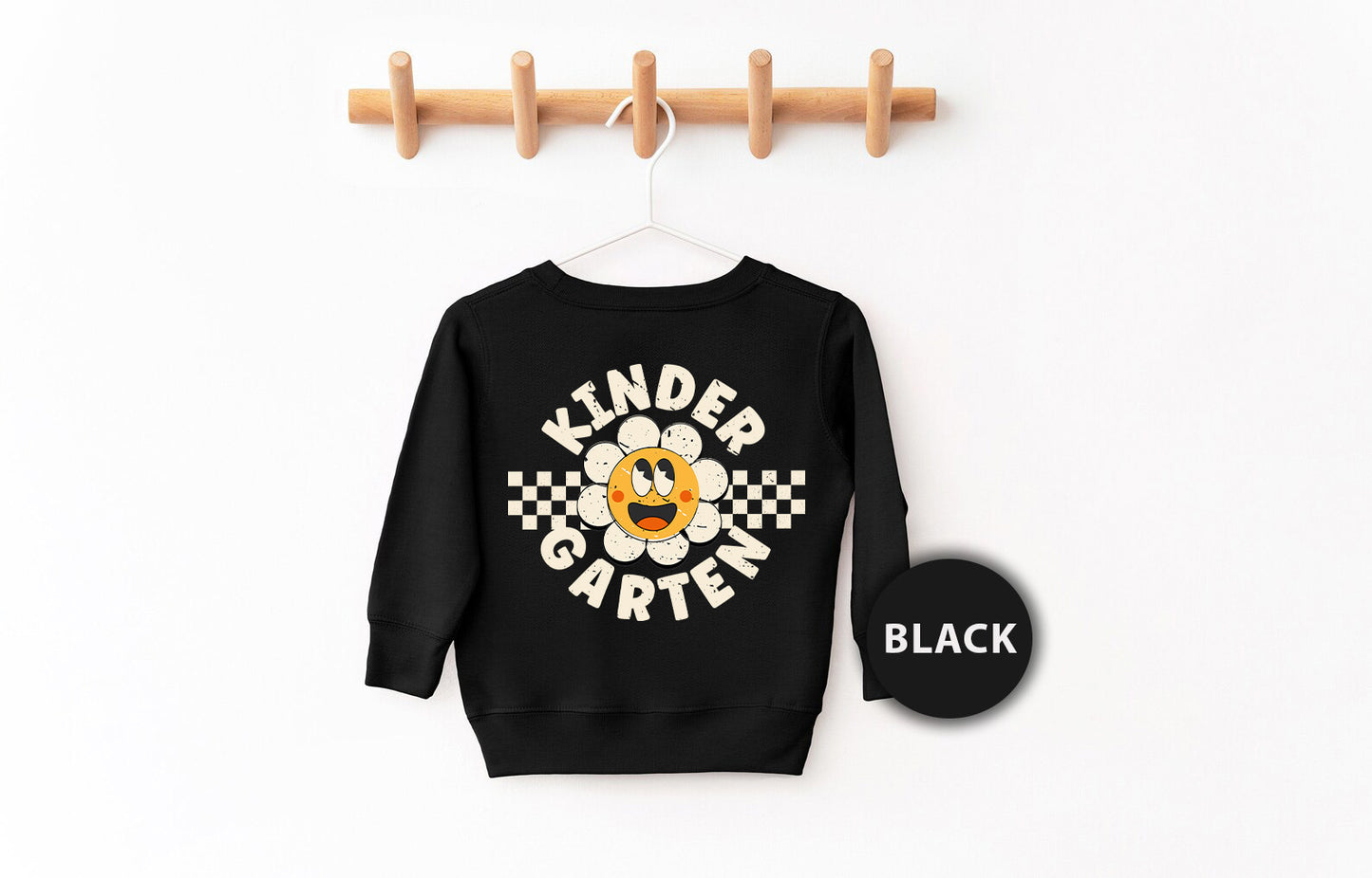 a black sweatshirt hanging on a clothes rack