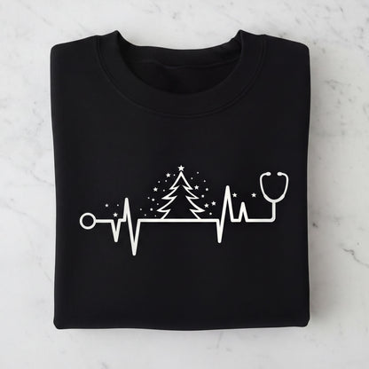 A black t-shirt with a white graphic design depicting a stethoscope, a Christmas tree, and a heart rate monitor line.