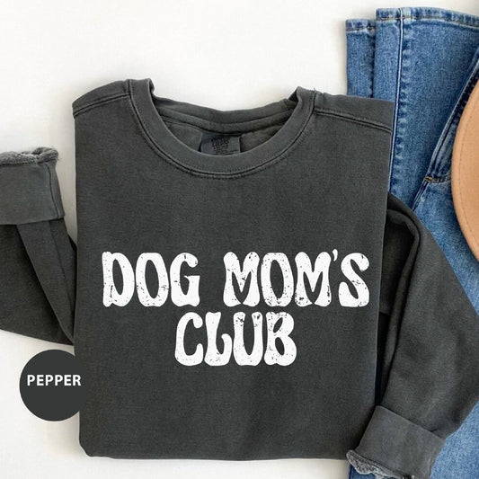 a dog mom's club shirt next to a pair of jeans