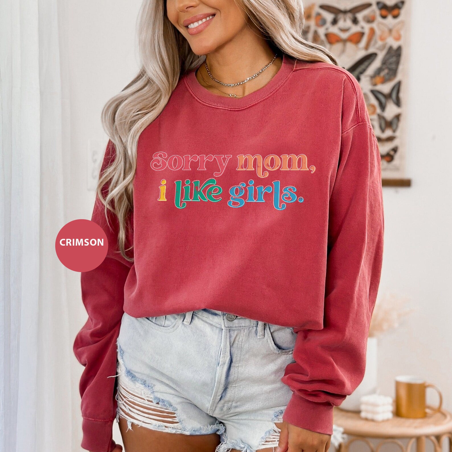 a woman wearing a red sweatshirt that says sorry mom, i like girls