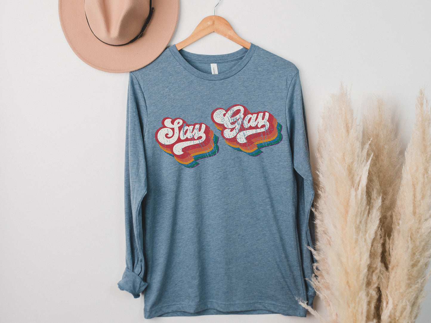 a t - shirt that says stay gay on it next to a hat