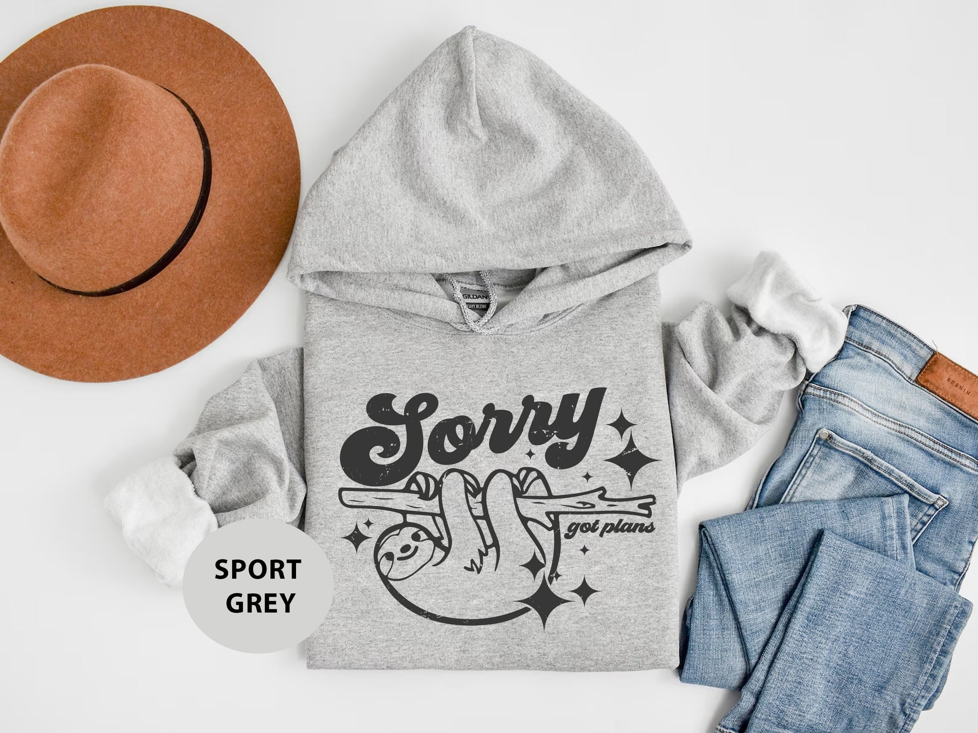 a hat, sweatshirt, jeans, and a pair of shoes on a white surface