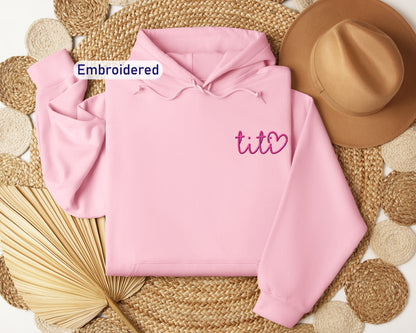 a pink hoodie with embroidered tico on it