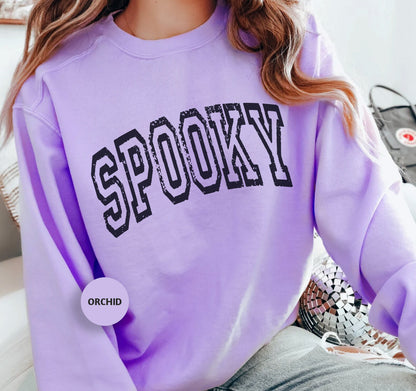 a woman wearing a purple sweatshirt with the word spooky on it