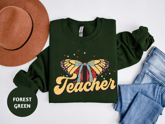 a green shirt with a butterfly on it and a hat next to it