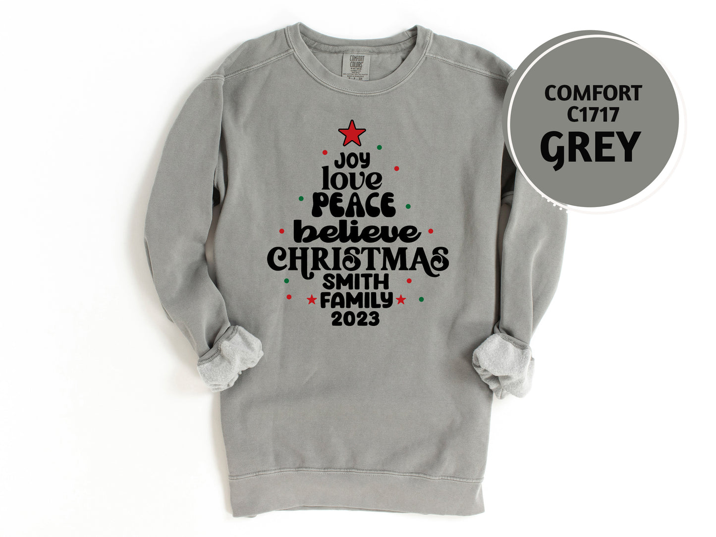 A gray sweatshirt with a Christmas tree design and text printed on it.