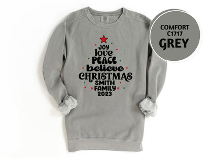 A gray sweatshirt with a Christmas tree design and text printed on it.
